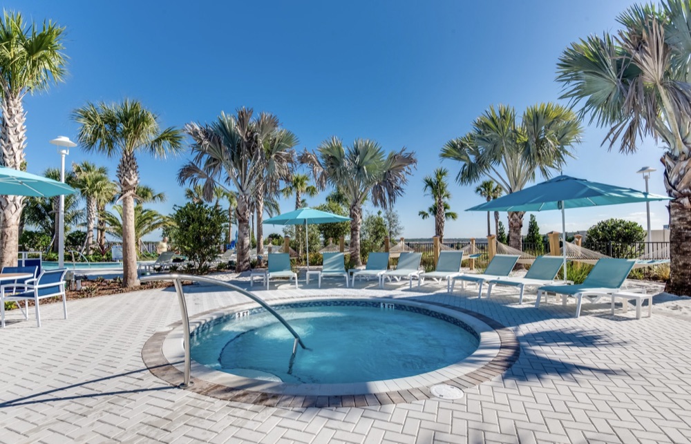 Communal hot tub surrounded by loungers and palm trees at Windsor Island Resort